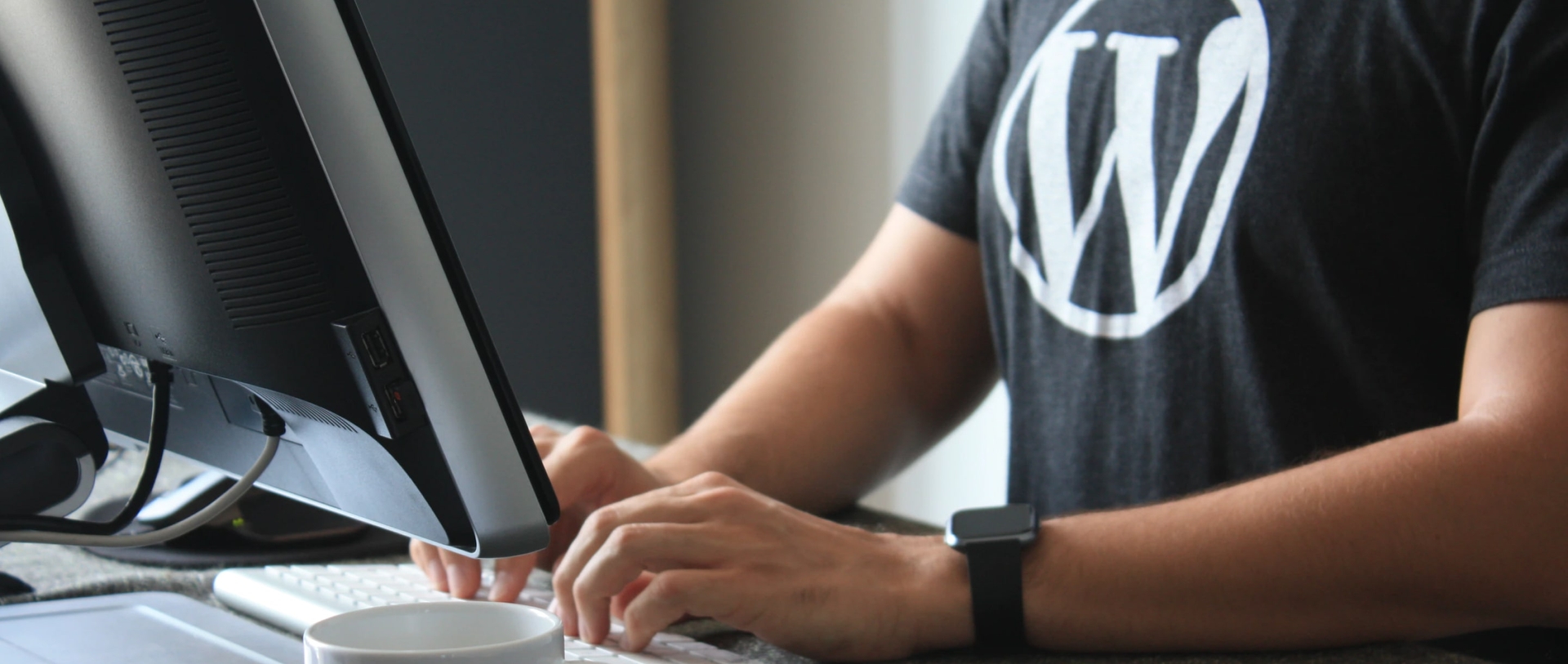 a man working on a PC wearing Wordpress t-shirt